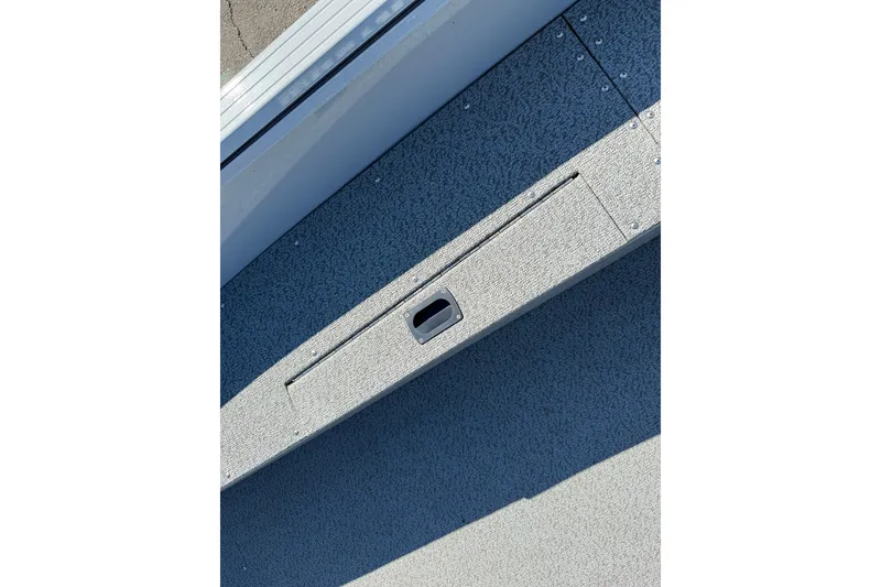 Slide: The Image of 2024 Smoker Craft Freedom 180 TL boat interior with textured flooring and storage compartment. - 24