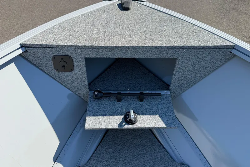 Slide: The Image of 2024 Smoker Craft Freedom 180 TL boat interior with storage compartment and carpeted deck. - 8