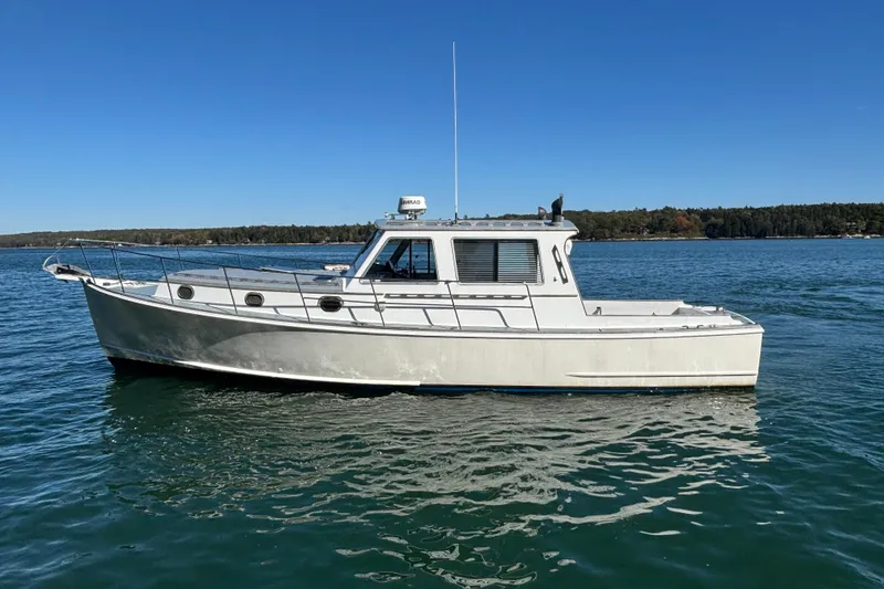Slide: The Image of 1985 Jarvis Newman 36 boat on calm water under clear blue sky. - 2