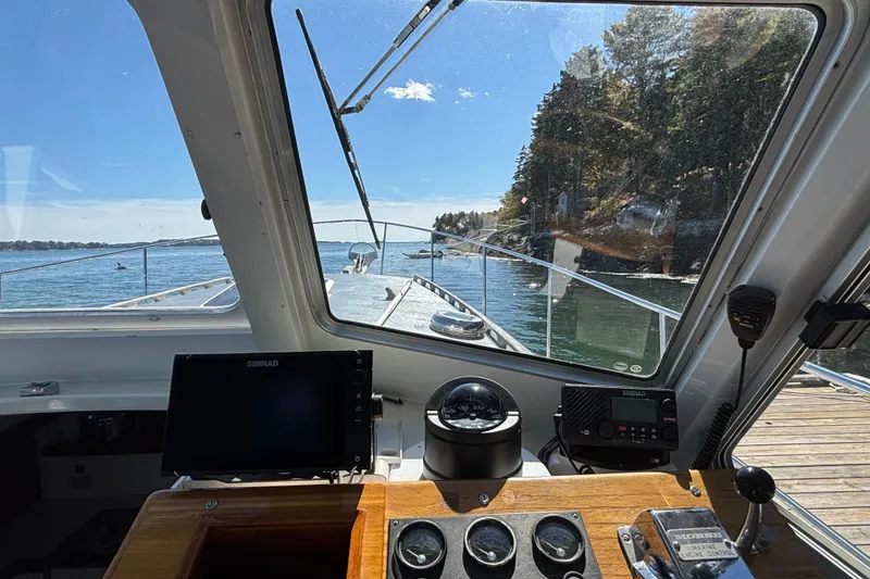Slide: The Image of View from the helm of a 1985 Jarvis Newman 36 boat, overlooking serene waters and shoreline. - 23