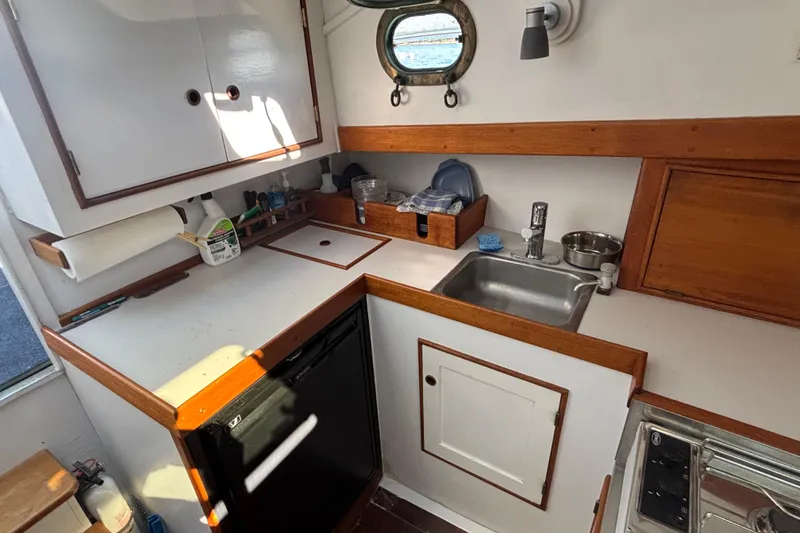 Slide: The Image of Compact kitchen area in a 1985 Jarvis Newman 36 boat, featuring a sink and storage. - 27