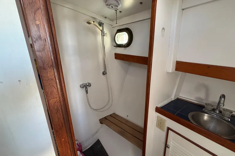 Slide: The Image of 1985 Jarvis Newman 36 boat interior shower and sink area with wooden accents. - 39