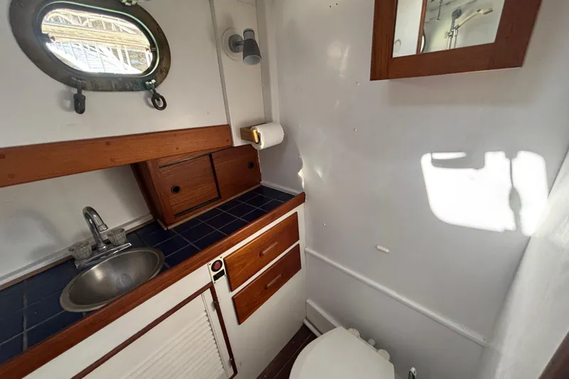 Slide: The Image of Compact bathroom in a 1985 Jarvis Newman 36 boat with wooden accents and porthole window. - 40