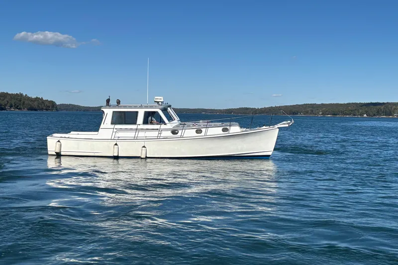 Slide: The Image of 1985 Jarvis Newman 36 boat on calm water under clear blue sky. - 5