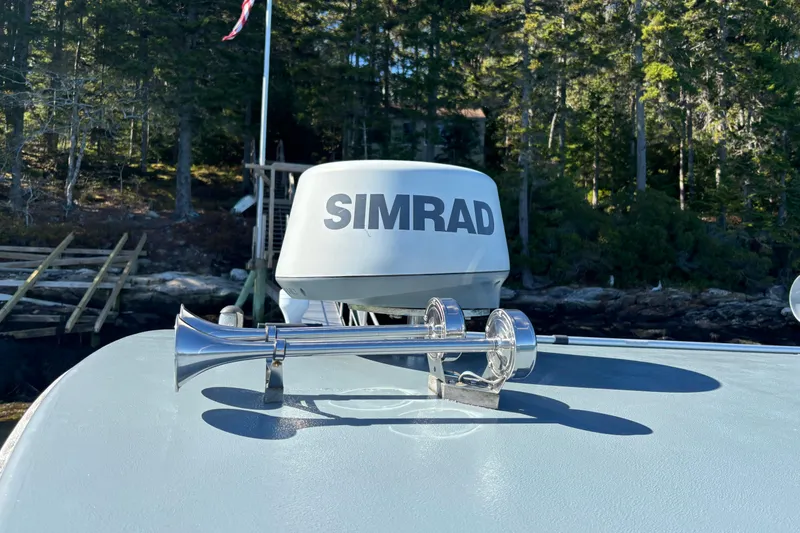 Slide: The Image of 1985 Jarvis Newman 36 boat with Simrad radar and chrome horn, docked near forest. - 51