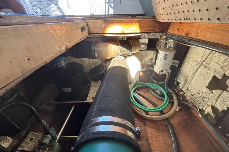 Slide: The Image of Engine compartment of a 1985 Jarvis Newman 36 boat, showing hoses and mechanical components. - 58