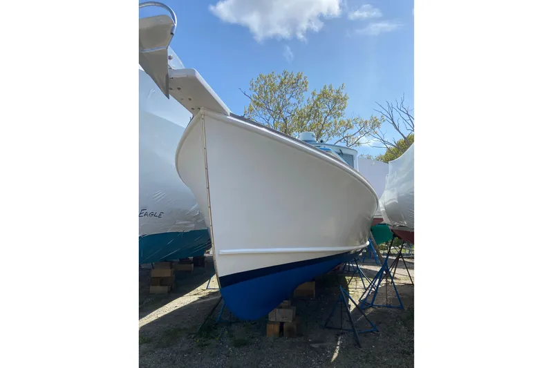 Slide: The Image of 1985 Jarvis Newman 36 boat on stands, blue hull, outdoors under clear sky. - 62