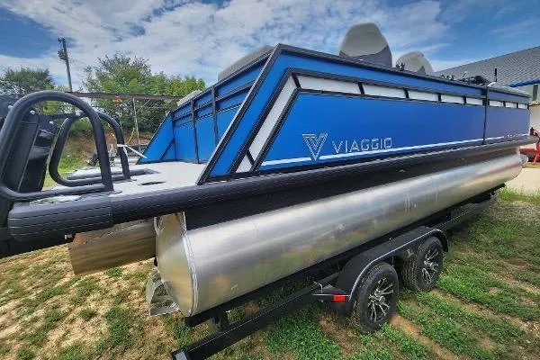 Slide: The Image of 2024 Viaggio Lago X22Q pontoon boat on trailer, blue and silver design. - 5