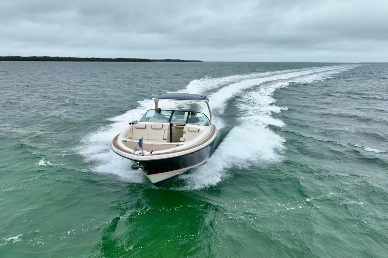 Slide: The Image of 2024 Chris-Craft Launch 35 GT cruising on open water under cloudy skies. - 12