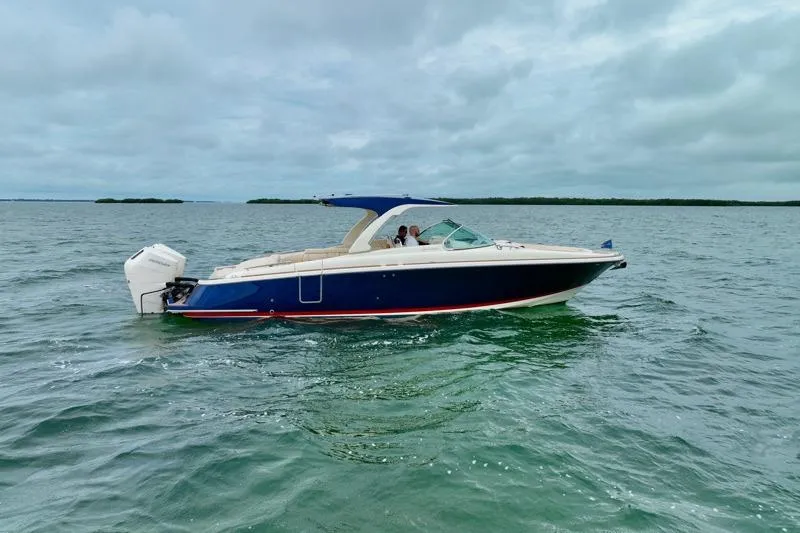 Slide: The Image of 2024 Chris-Craft Launch 35 GT boat cruising on open water under cloudy skies. - 14