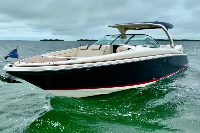 Slide: The Image of 2024 Chris-Craft Launch 35 GT boat cruising on open water under cloudy skies. - 2