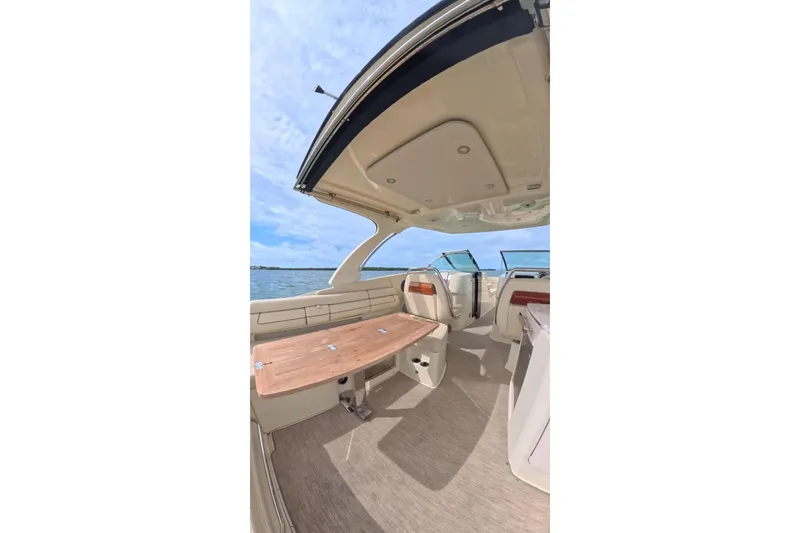 Slide: The Image of 2024 Chris-Craft Launch 35 GT interior with wooden table and open deck view. - 20
