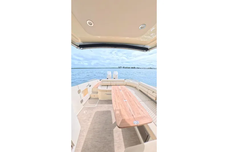 Slide: The Image of 2024 Chris-Craft Launch 35 GT boat interior with elegant seating and wooden table on open water. - 22