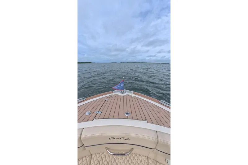 Slide: The Image of 2024 Chris-Craft Launch 35 GT cruising on open water under a cloudy sky. - 30