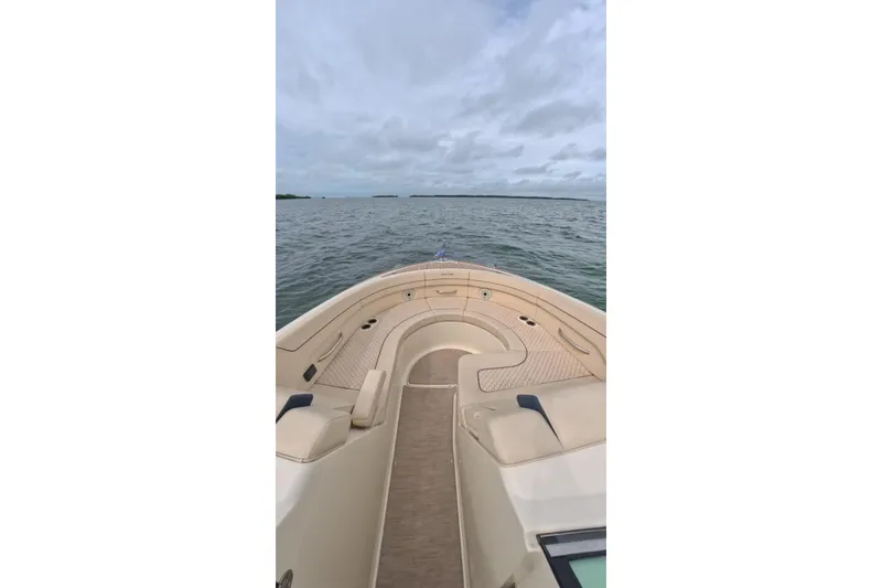 Slide: The Image of 2024 Chris-Craft Launch 35 GT boat cruising on open water under cloudy skies. - 33