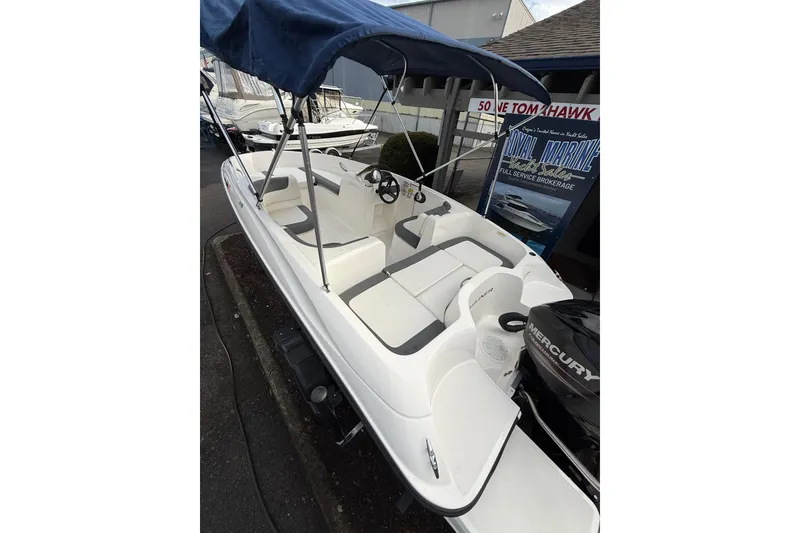 Slide: The Image of 2019 Bayliner Element E16 boat with canopy and Mercury engine displayed at a marina. - 6