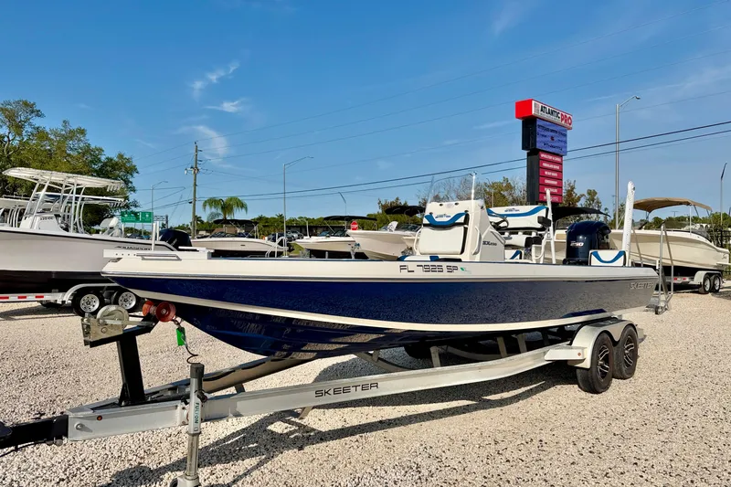 The Image of 2020 Skeeter SX230 boat on trailer at dealership under clear blue sky. - 0