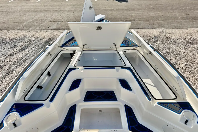 Slide: The Image of 2020 Skeeter SX230 boat interior with open storage compartments on a gravel surface. - 24