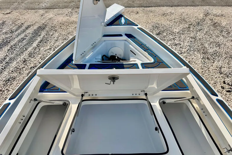 Slide: The Image of 2020 Skeeter SX230 boat with open storage compartments on a gravel surface. - 25