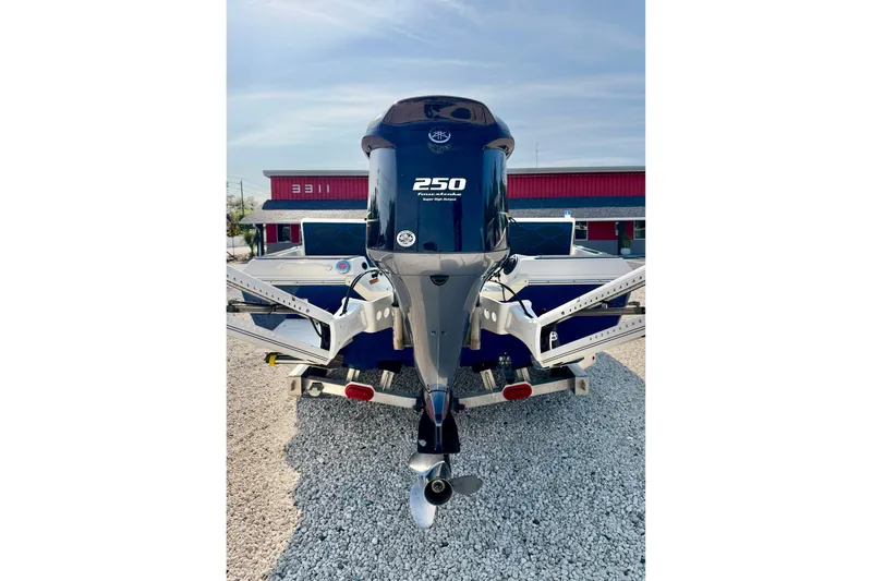 Slide: The Image of 2020 Skeeter SX230 boat with powerful 250 horsepower engine, parked on gravel. - 30