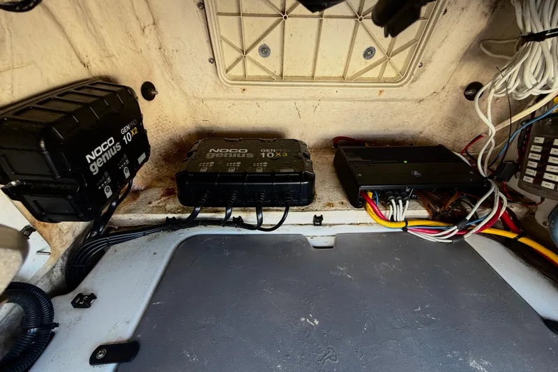 Slide: The Image of Electrical components inside a 2020 Skeeter SX230 boat, featuring NOCO Genius chargers. - 33