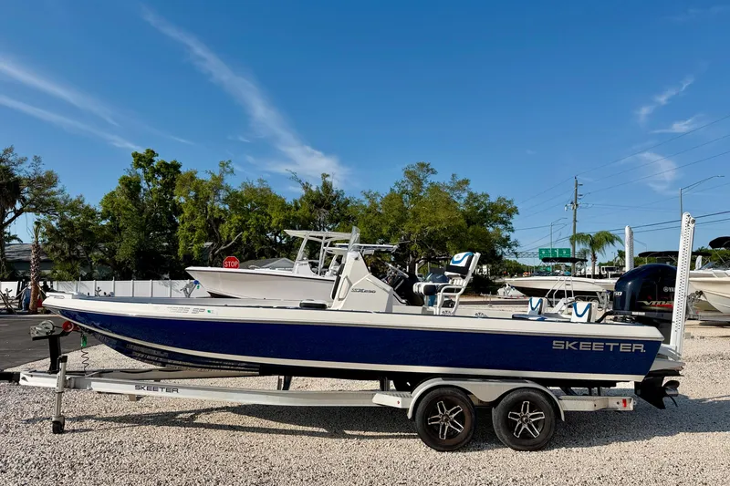 Slide: The Image of 2020 Skeeter SX230 boat on trailer, parked outdoors under clear blue sky. - 4