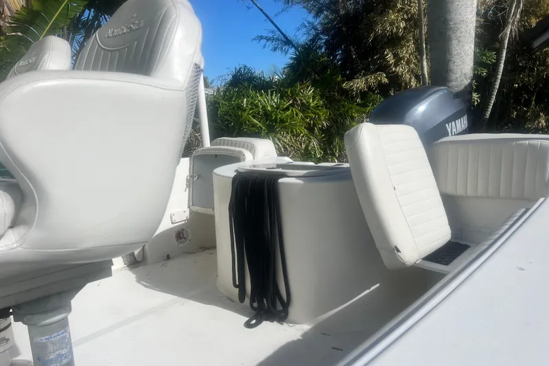 Slide: The Image of 2008 NauticStar 2000 Offshore boat interior with Yamaha engine, featuring white seating and lush greenery. - 10
