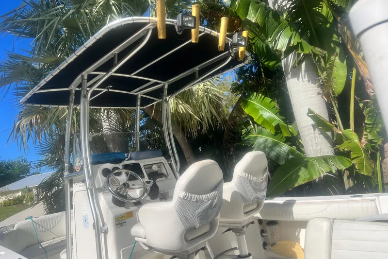 Slide: The Image of 2008 NauticStar 2000 Offshore boat with T-top and dual seats, surrounded by tropical foliage. - 12
