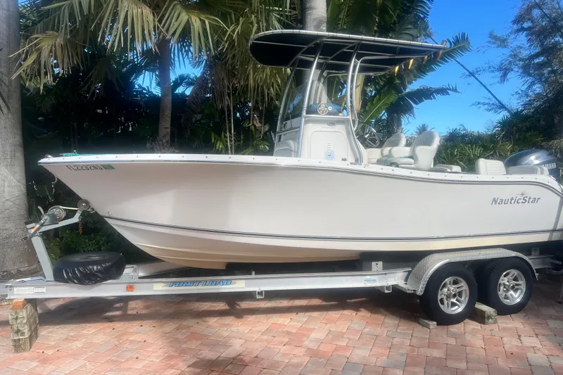 Slide: The Image of 2008 NauticStar 2000 Offshore boat on trailer, surrounded by tropical foliage. - 14