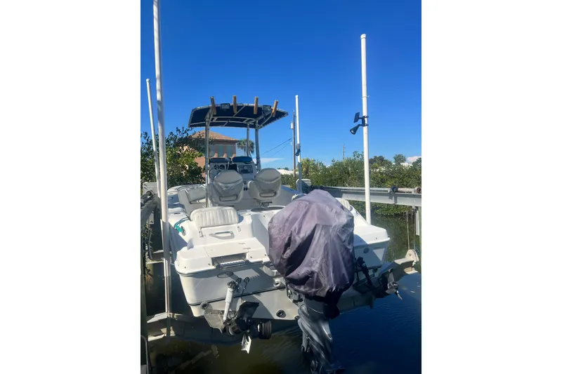 Slide: The Image of 2008 NauticStar 2000 Offshore boat docked, rear view with covered motor, clear blue sky. - 2