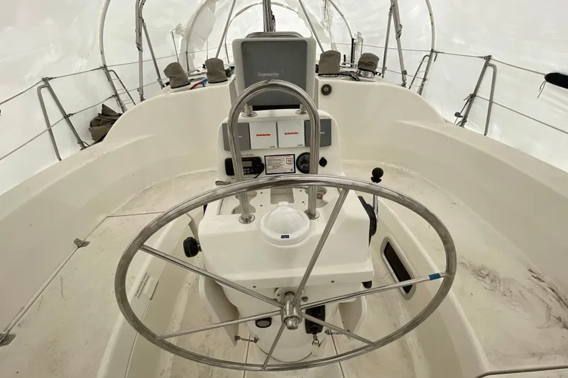 Slide: The Image of Cockpit of 1999 Hunter 380 sailboat with steering wheel and navigation equipment. - 11