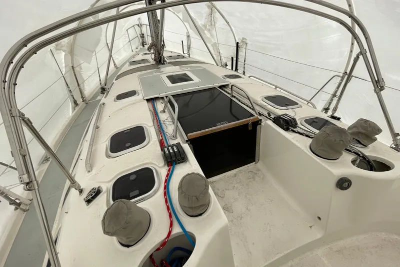 Slide: The Image of 1999 Hunter 380 sailboat deck under protective cover, showcasing hatches and rigging. - 13