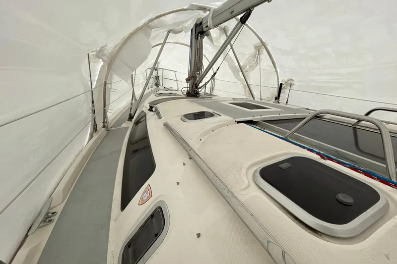 Slide: The Image of 1999 Hunter 380 sailboat under protective cover, showcasing deck and rigging details. - 15