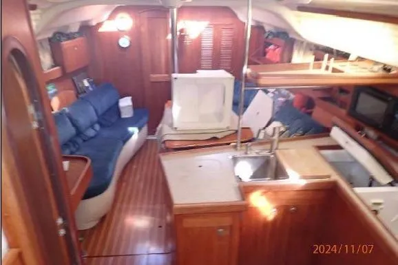 Slide: The Image of Interior of a 1999 Hunter 380 sailboat with wooden finishes and cozy seating area. - 19