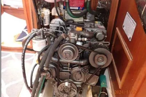 Slide: The Image of Engine compartment of a 1999 Hunter 380 sailboat, showcasing mechanical components and hoses. - 20