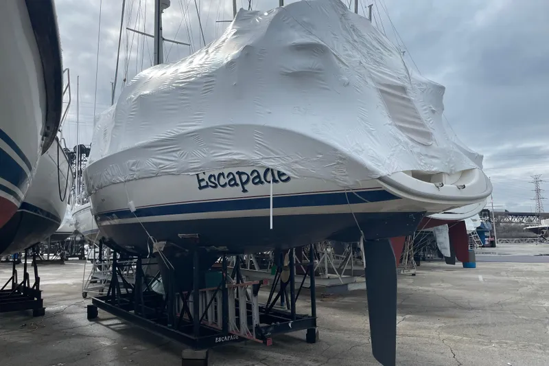 Slide: The Image of 1999 Hunter 380 sailboat "Escapade" covered in protective wrap, stored on land. - 4