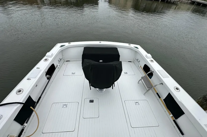Slide: The Image of 1975 Bertram 31 boat deck with covered seating, docked by calm waters. - 11