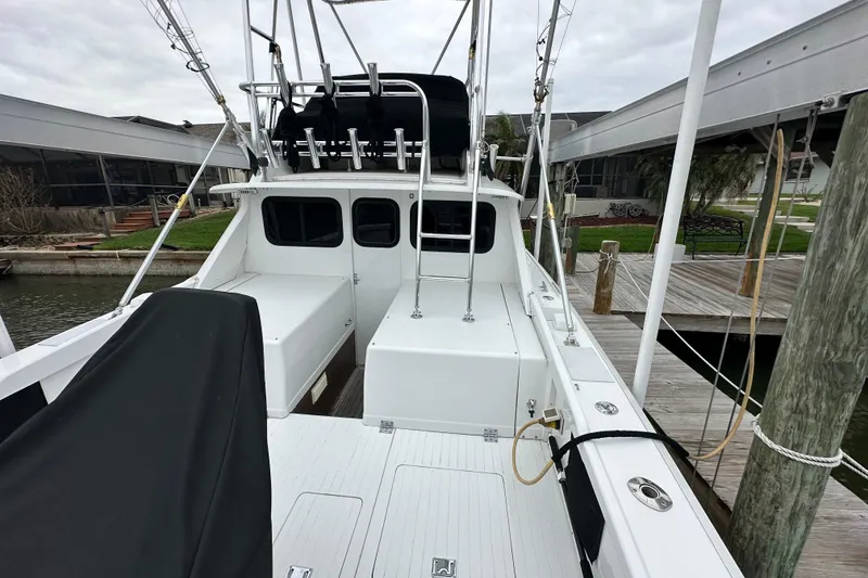 Slide: The Image of 1975 Bertram 31 boat docked, showcasing spacious deck and fishing equipment. - 16