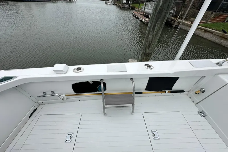Slide: The Image of 1975 Bertram 31 boat deck with ladder, docked by calm waters. - 17
