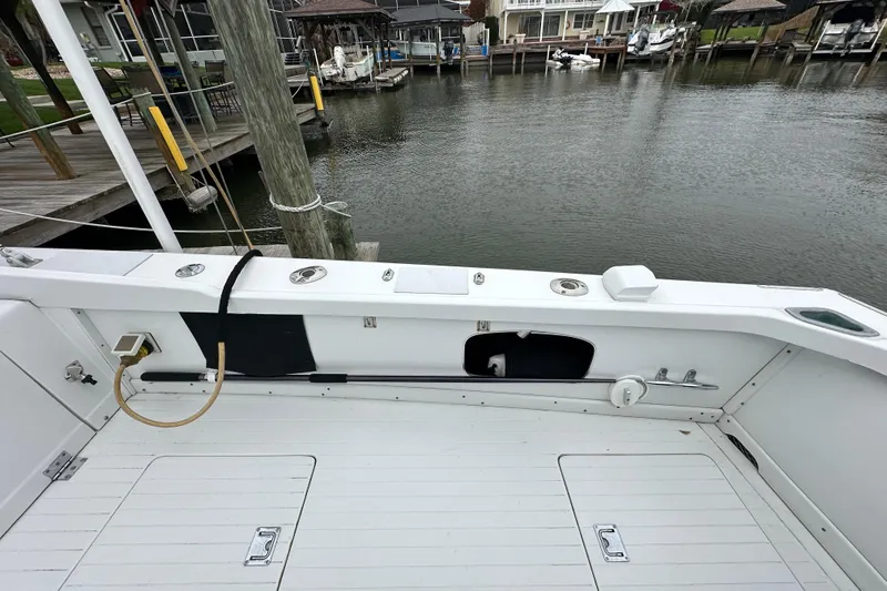 Slide: The Image of 1975 Bertram 31 boat deck with marina view, featuring clean white surfaces and dockside surroundings. - 18