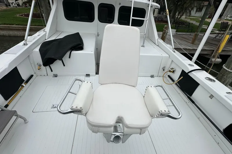 Slide: The Image of 1975 Bertram 31 boat deck with white captain's chair and fishing rod holders. - 20