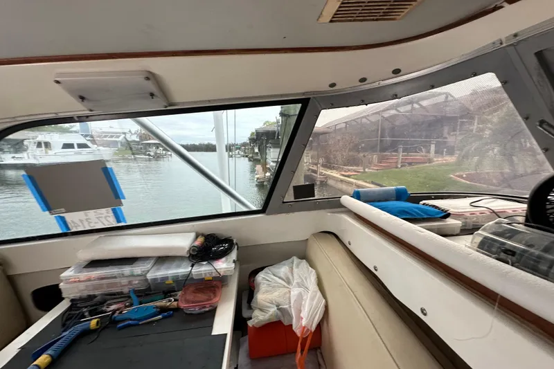 Slide: The Image of Interior view of a 1975 Bertram 31 boat with fishing gear and marina backdrop. - 31