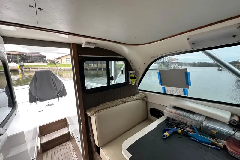 Slide: The Image of Interior of a 1975 Bertram 31 boat with seating and dockside view. - 33