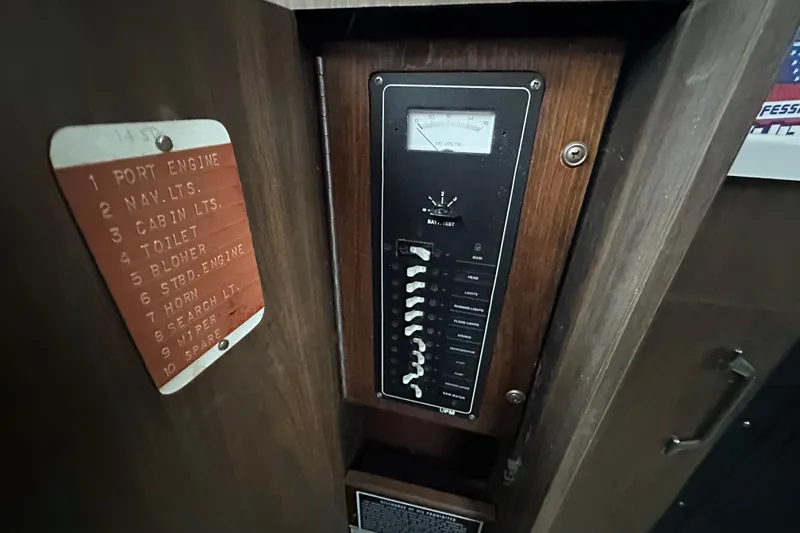 Slide: The Image of Electrical panel of a 1975 Bertram 31 boat with labeled switches and voltmeter. - 38