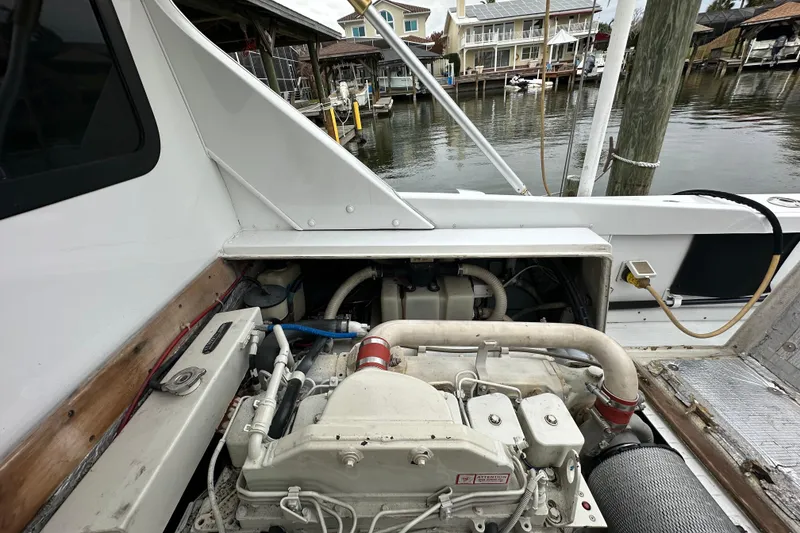 Slide: The Image of 1975 Bertram 31 boat engine compartment with visible machinery and dockside view. - 39