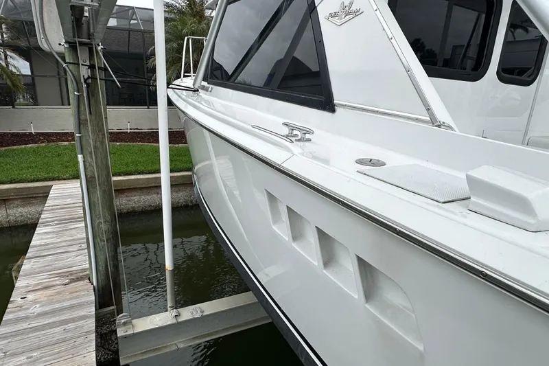 Slide: The Image of 1975 Bertram 31 boat docked, showcasing sleek white exterior and classic design. - 4