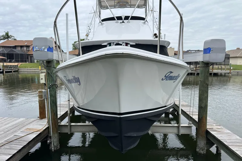 Slide: The Image of 1975 Bertram 31 boat docked, front view, with "Tenacity" on the hull. - 5
