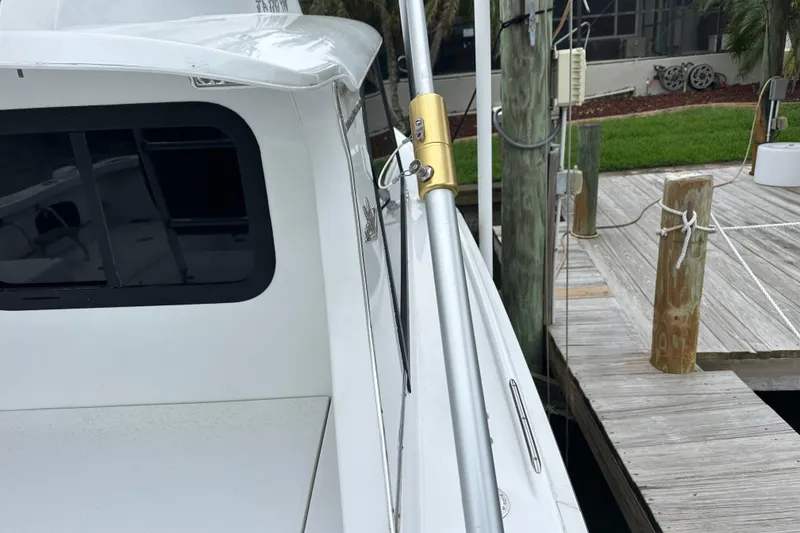 Slide: The Image of 1975 Bertram 31 boat docked, showcasing side view with fishing rod holder. - 50