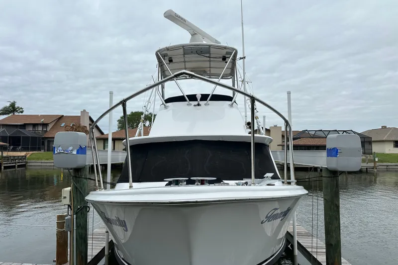 Slide: The Image of 1975 Bertram 31 boat docked at marina, front view with overcast sky. - 6