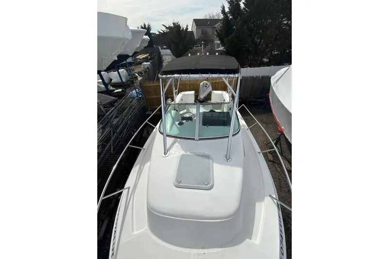 Slide: The Image of 2002 Wellcraft 22 Coastal Walkaround O/B boat with canopy, docked outdoors. - 13